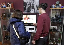 Una mujer visiona las imágenes digitales que quiere imprimir en un establecimiento fotográfico de la ciudad.