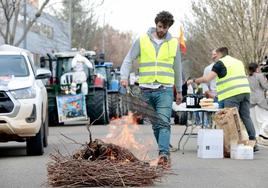 Los manifestantes prenden una hoguera ante la Consejería de Agricultura para preparar el almuerzo