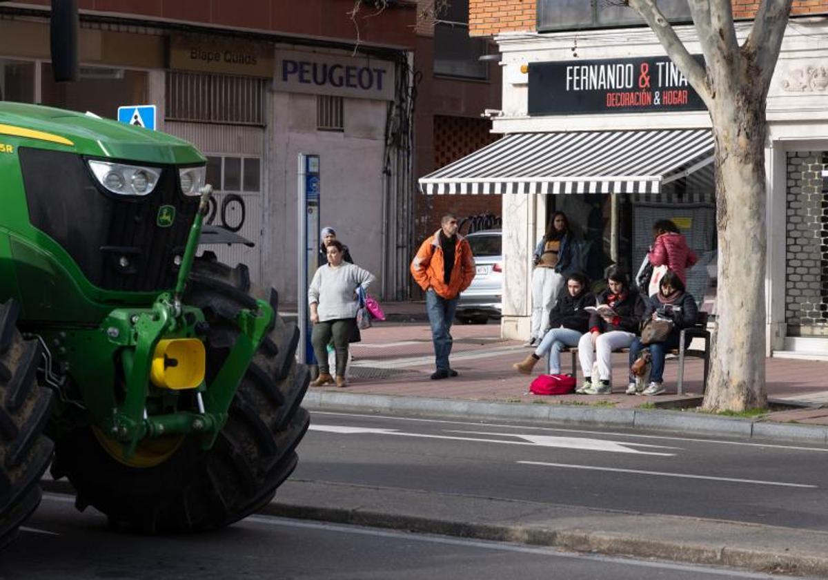 Estudiantes y trabajadores esperan el autobús en la Avenida de Gijón, frente al colegio Cristo Rey.