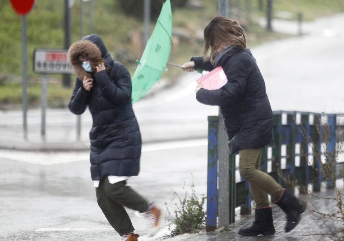 Dos mujeres se protegen del viento durante el último temporal.