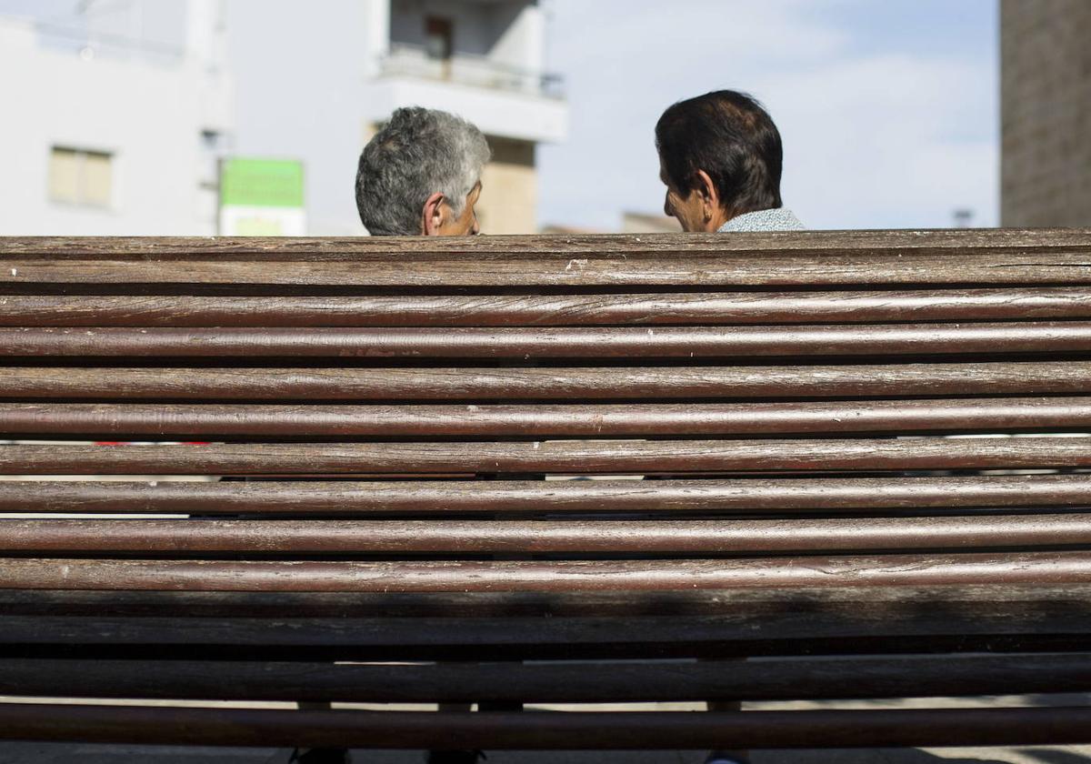 Dos vecinas mayores conversan en un pueblo.