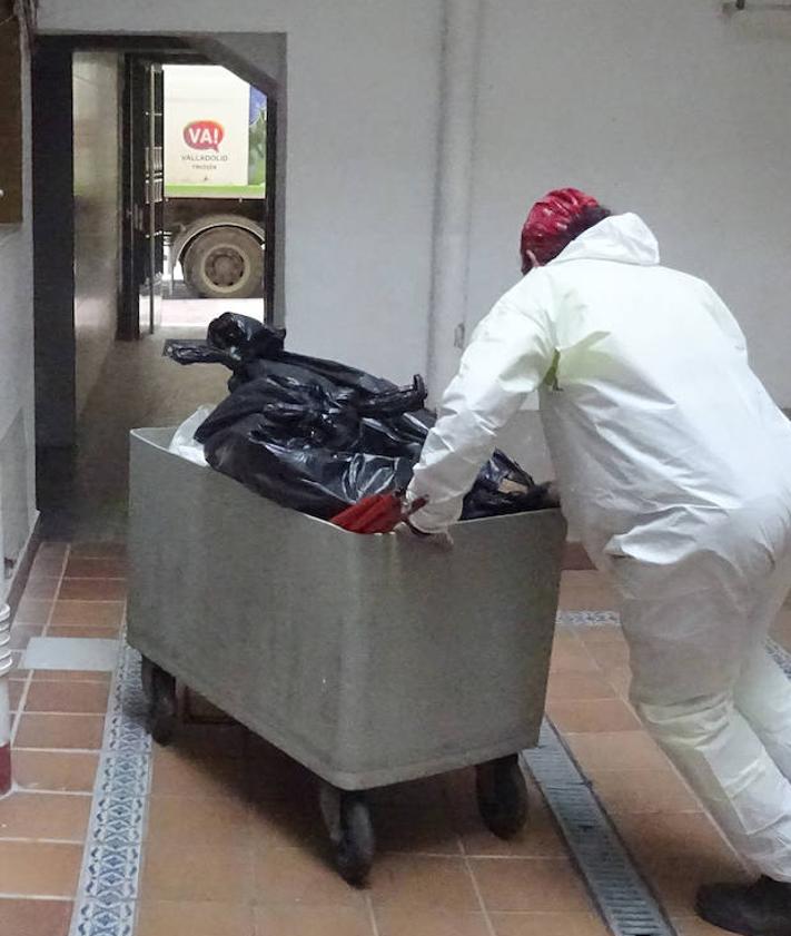 Imagen secundaria 2 - Policías locales en la vivienda de la vecina de Corpus Christi y cadena de los operarios de Limpieza para retirar la basura acumulada en su interior.