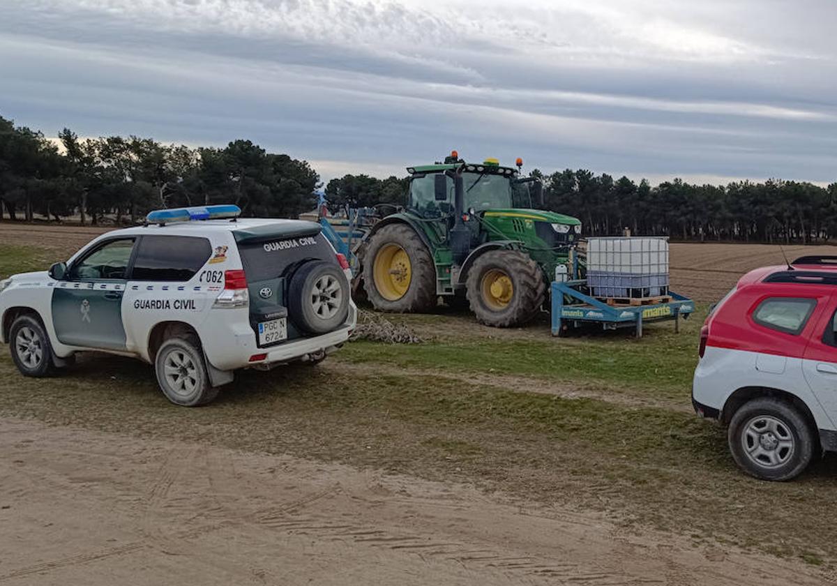 Un vehículo de la Guardia Civil junto al tractor con el que se aplicaba el producto tóxico.