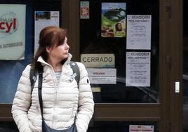 Una mujer, frente a un local con anuncios de ofertas de viajes.