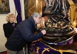 Un joven enciende una vela junto al altar de la iglesia de Jesús.