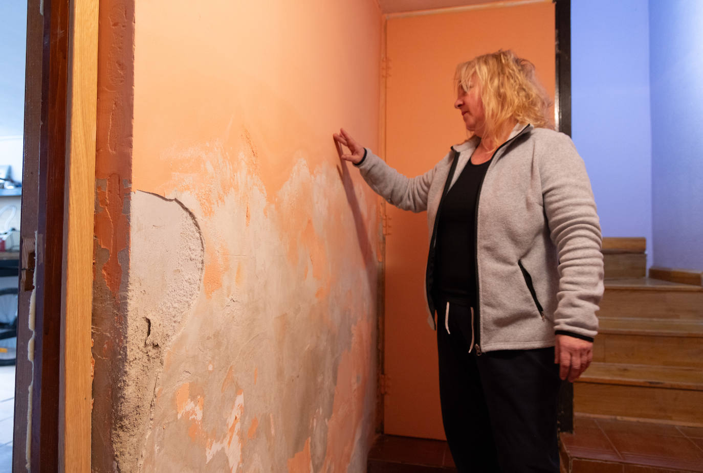 Elena muestra una pared dañada por la inundación de hace mes y medio.