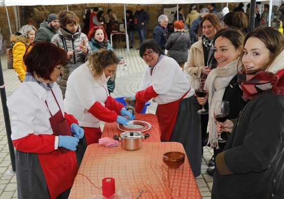 Asistentes a la jornada asisten a una demostración de hacer chorizos artesanalmente.