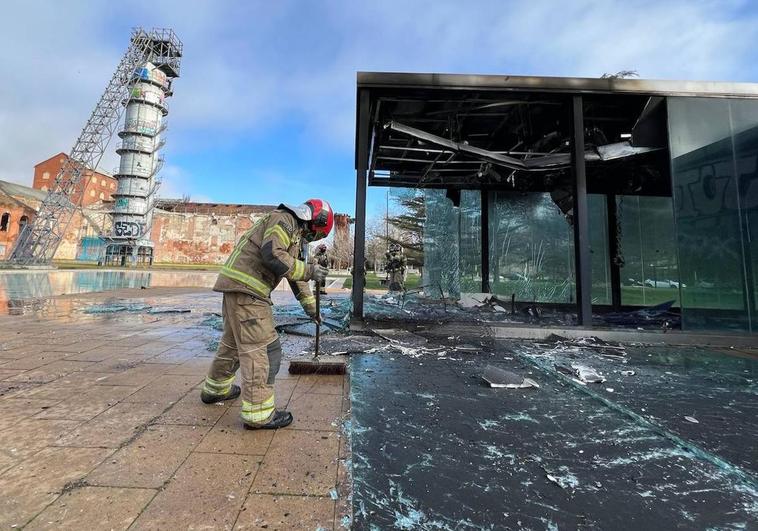 Un bombero limpia los cristales del quiosco incendiado de Las Norias.