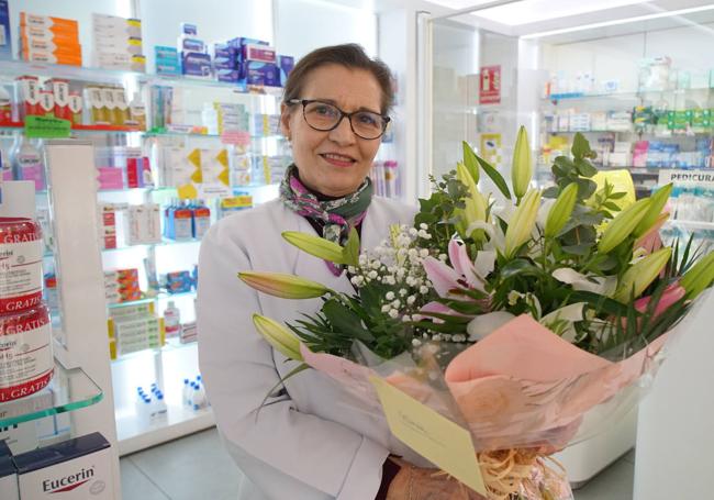 Matilde en la farmacia Esteban con su ramo de flores