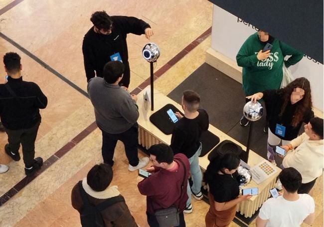 Jóvenes escanean su iris en un centro comercial de Murcia.