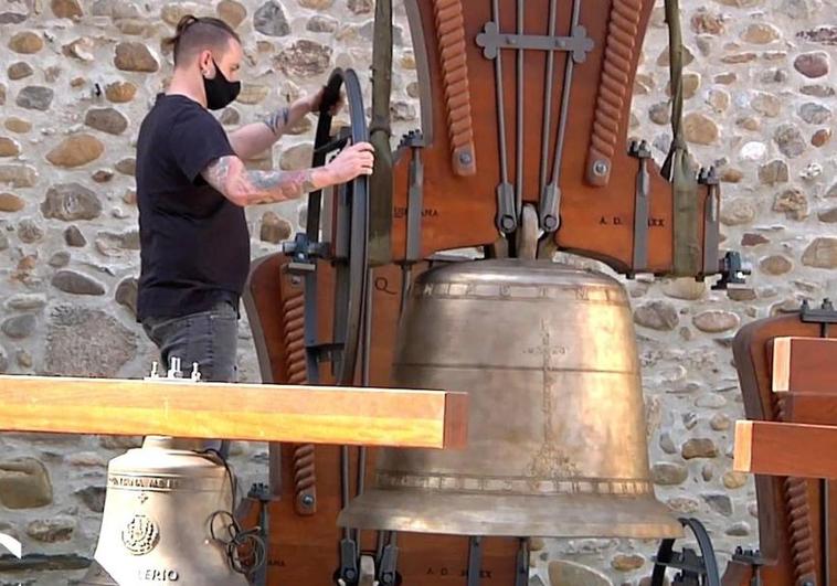 Un artesano de Saldaña descarga una campana junto a una iglesia.