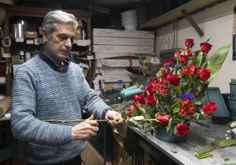 Leopoldo Adiego, dueño de la Floristería Rebeca, prepara uno de los adornos florales para la Semana Santa.