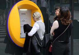 Unas mujeres sacan dinero de un cajero automático en Segovia.