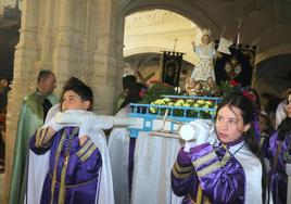 Niños nazarenos portan la imagen del Niño de Pascua.