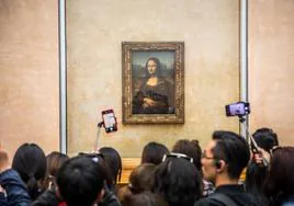 Los visitantes se agolpan y toman fotografías de La Gioconda, en el Museo del Louvre.