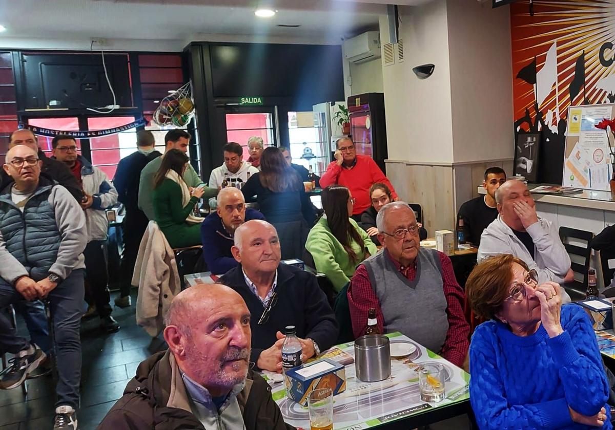 Numerosas personas presencian un partido de fútbol en el interior de un local de la capital segoviana.