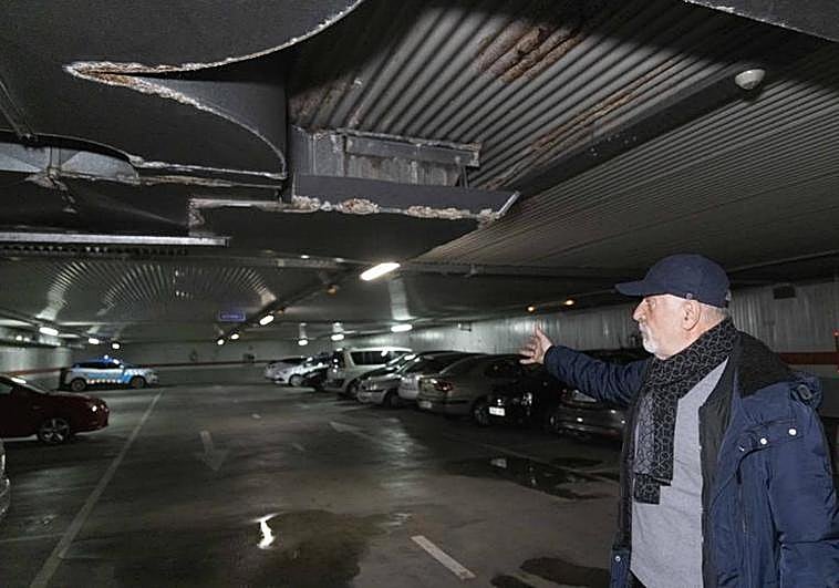 Carlos Morán, usuario del aparcamiento de la avenida de Palencia, señala el techo carcomido por las humedades de las filtraciones.
