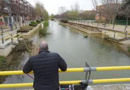 Un hombre observa el estado del Esgueva, que aún cubre sus paseos inferiores, entre las calles Cigüeña y Templarios.