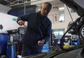Un mecánico comprueba el nivel de aceite de un vehículo.