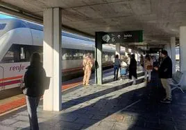 Varios pasajeros esperan la llegada del tren en el andén de la estación Segovia-Guiomar.