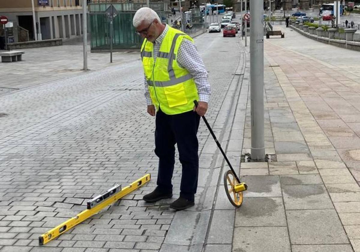 Un operario de la empresa mide el desnivel de uno de los baches.