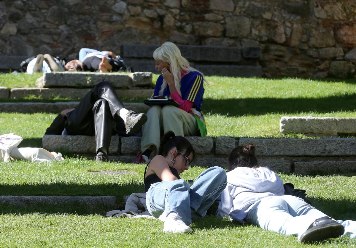 Jóvenes tumbadas toman el sol bajo los arcos del Acueducto, este miércoles.