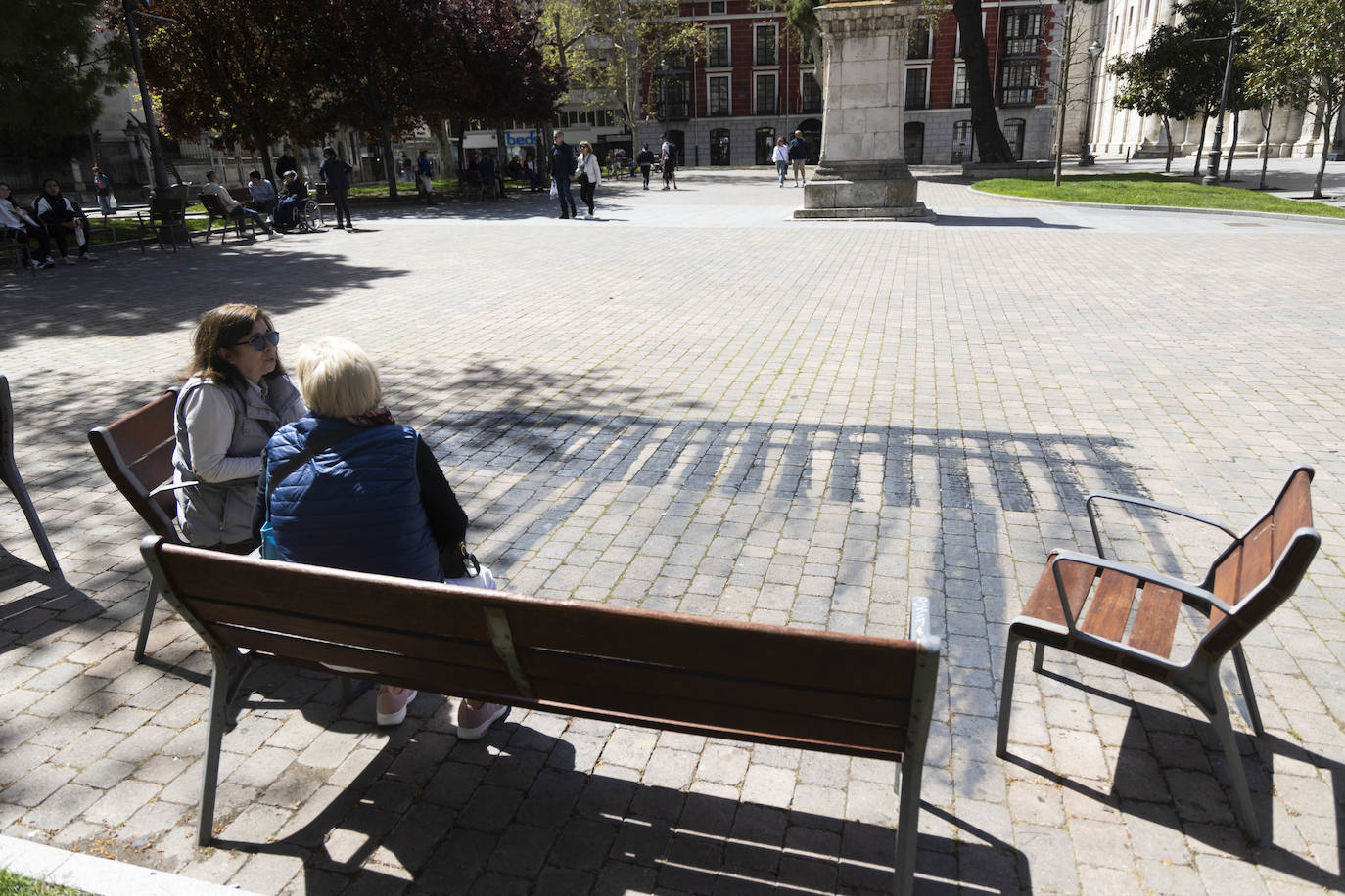 El cueducto que proyecta la sombra de unos bancos en la plaza de la Universidad.