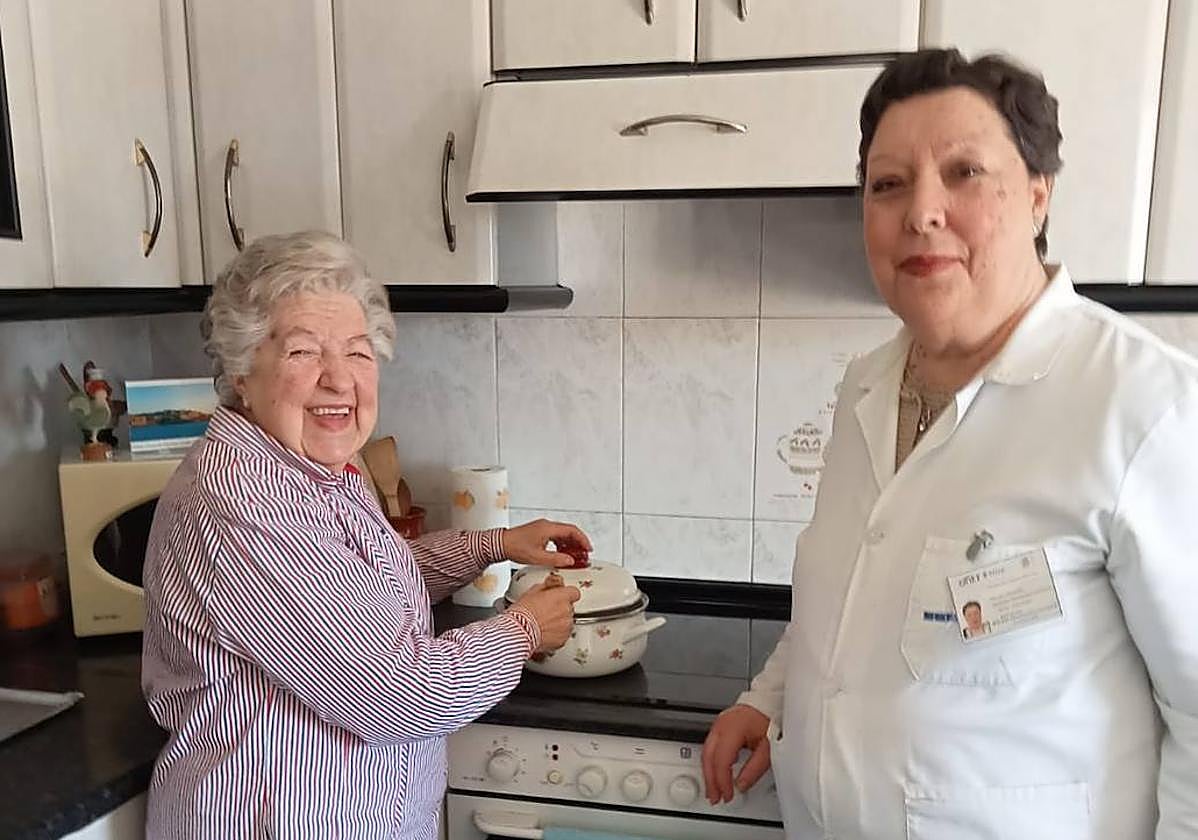 Dolores Arenillas, con la auxiliar que la atiende en casa.