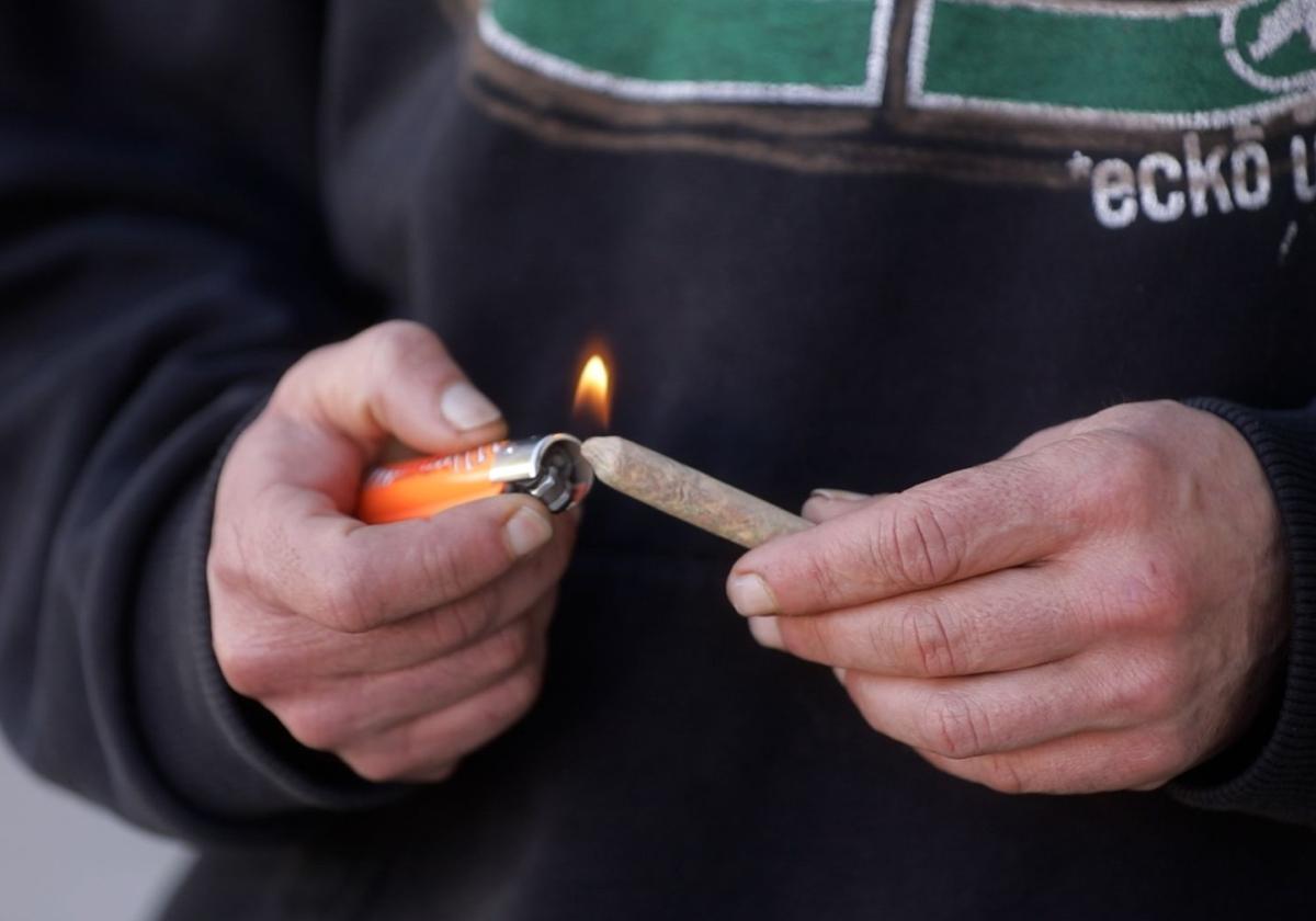 Un consumidor de marihuana se prepara un porro.