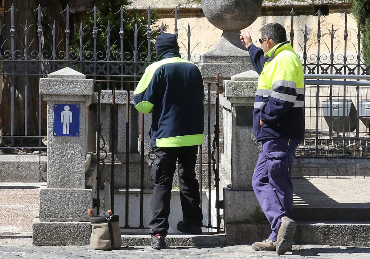 Dos operarios en uno de los aseos públicos de la Plaza Mayor, ahora cerrados.