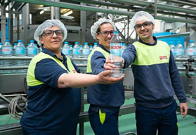 Varios trabajadores de Bezoya muestran uno de los envases.