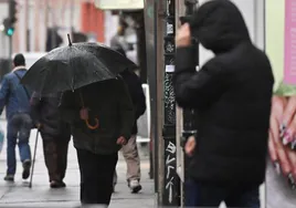 Un hombre se protege de la lluvia en Valladolid, en una imagen de archivo.
