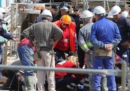 Foto de archivo de personal de Emergencias Sanitarias, bomberos y policías atendiendo a una persona accidentada en una construcción.