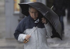 Un hombre se protege de la lluvia en Valladolid en una imagen de archivo.