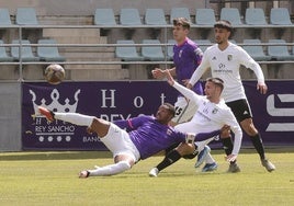 Edipo intenta hacerse con el balón ante la oposición de la defensa del Burgos B.