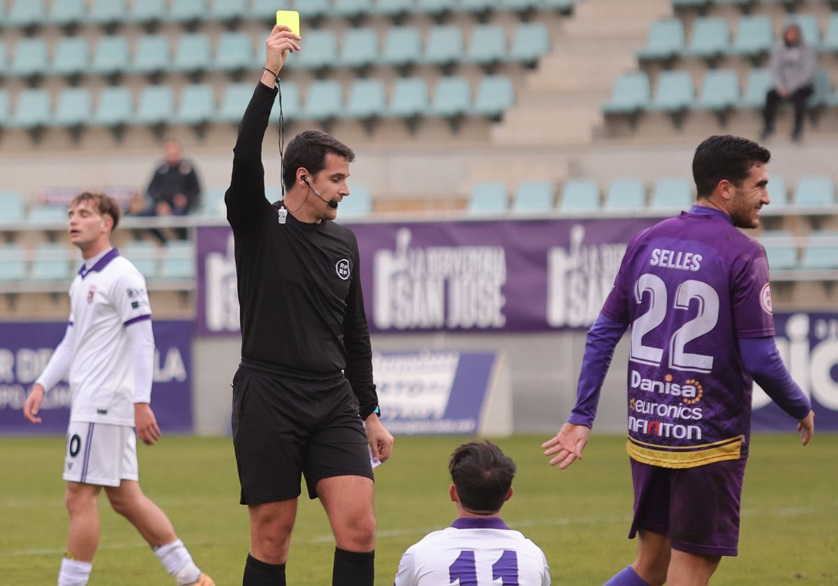 El colegiado del derbi de la primera vuelta muestra la tarjeta amarilla a Álex Gómez