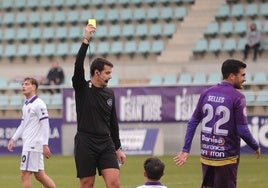 El colegiado del derbi de la primera vuelta muestra la tarjeta amarilla a Álex Gómez