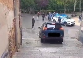 Un coche desciende por las escaleras por la calle de la Puerta de la Luna ante el público expectante.