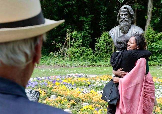 Abrazo frente al busto de Tagore.