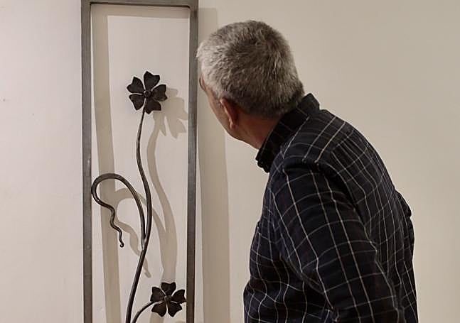 Un visitante observa una de las creaciones en forja.