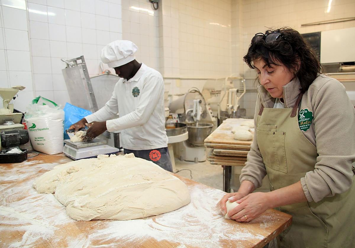 La pastelera Rocío Gil y uno de los trabajadores de su obrador, durante el proceso de amasado de sus productos.