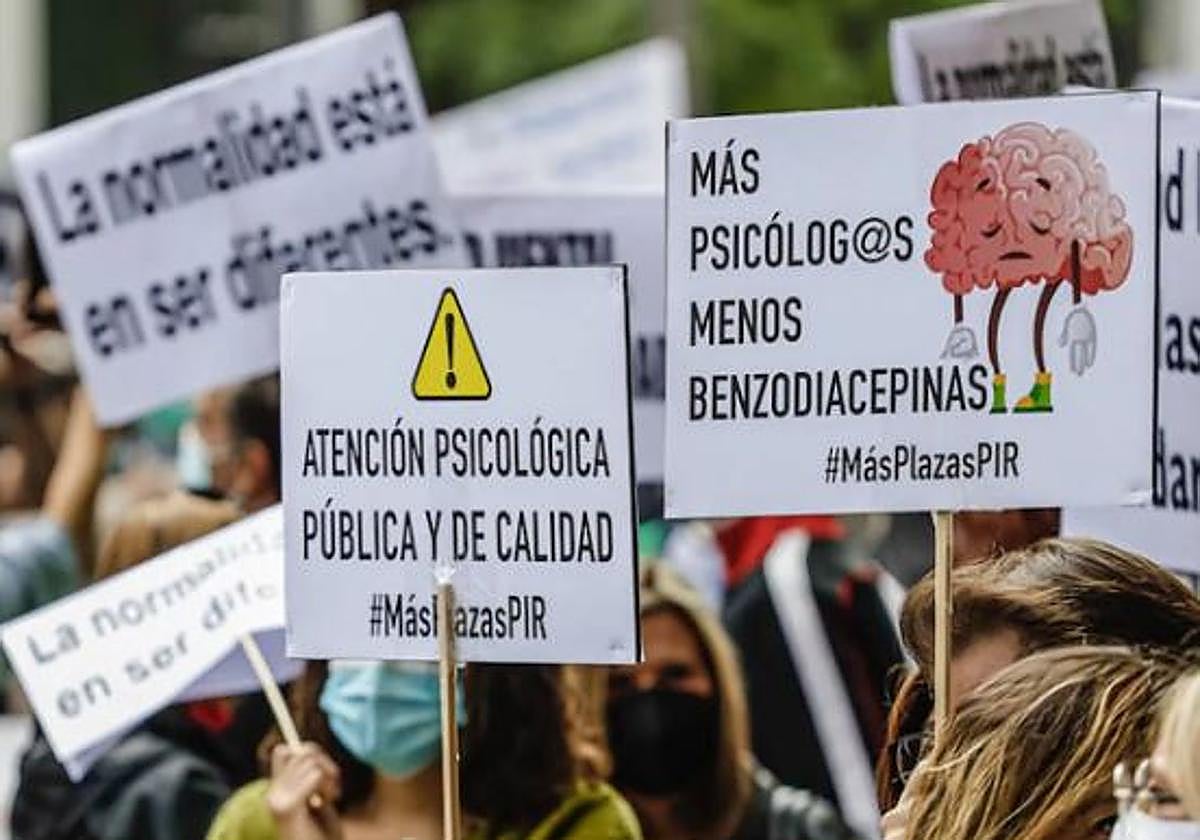 Varias personas sostienen diferentes pancartas en una marcha con motivo del Día Mundial de la Salud Mental.