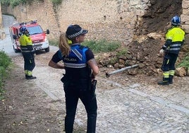 Los bomberos y policía observan el derrumbe en la subida al Parral.