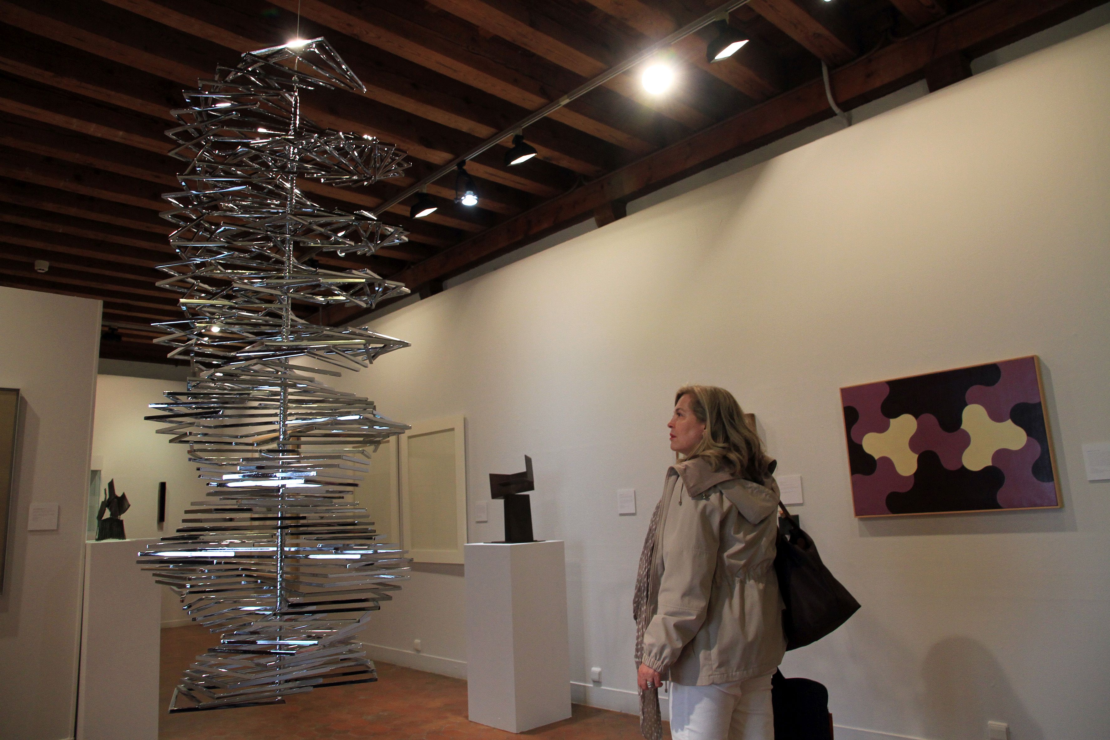 Una mujer observa una de las obras de la exposición en el Torreón de Lozoya.