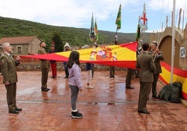 Acto castrense de izado de la bandera, con la participación de dos vecinas.