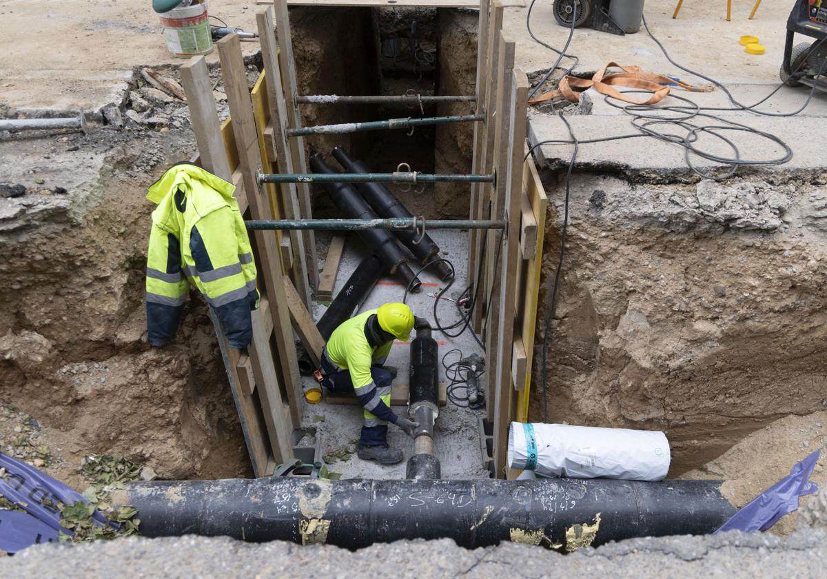 Un operario trabaja en el ajuste de una canalización de la red de calor en la calle Eusebio González Suárez de Valladolid.