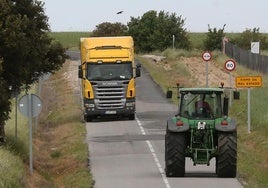 Un camión y un tractor a punto de cruzarse por la carretera SG-322, en Marugán.