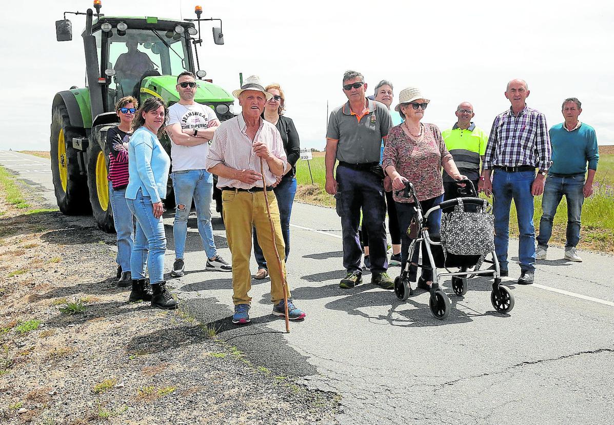 Vecinos de Muñopedro, a la salida del pueblo, en la carretera objeto de las quejas por su deficiente estado.