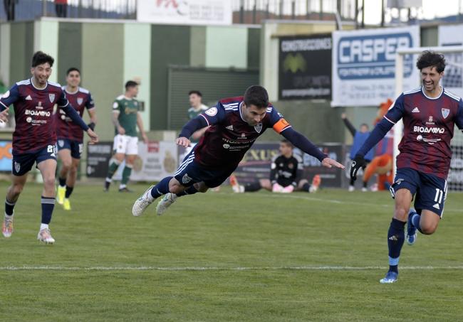 Manu se lanza en plancha sobre el césped tras marcar un gol al Cacereño.