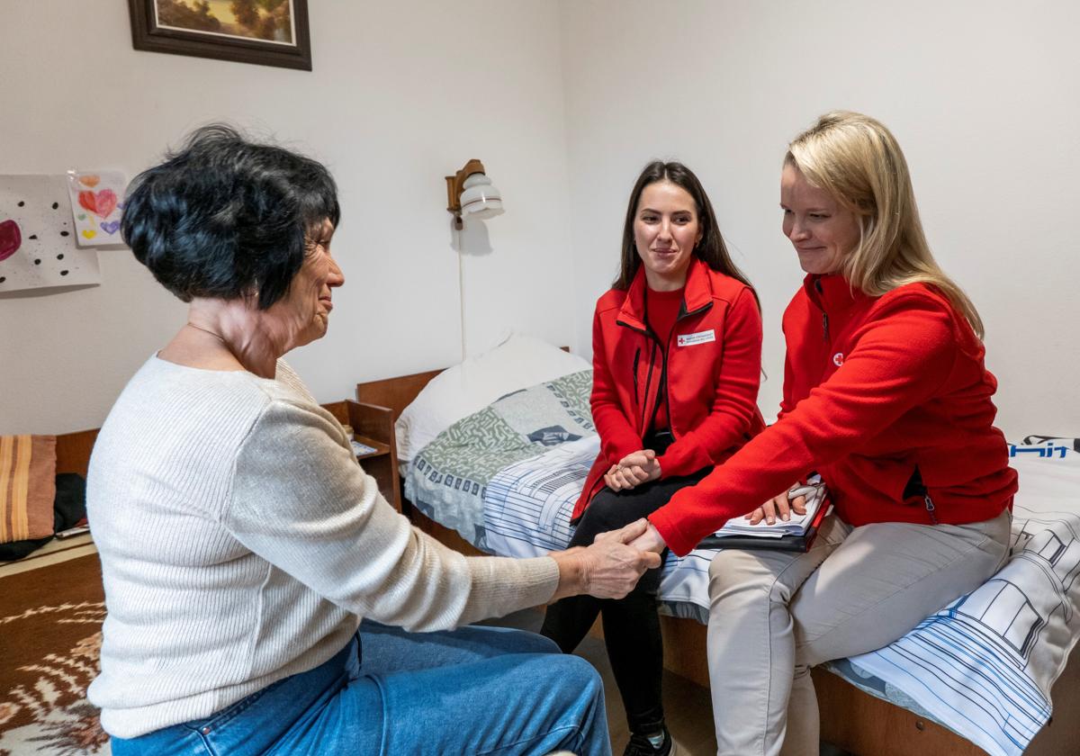 Voluntarias de Cruz Roja atienden a una mujer en su domicilio.